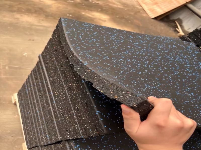 A close-up shot showing the dense texture of a rubber gym floor tile.